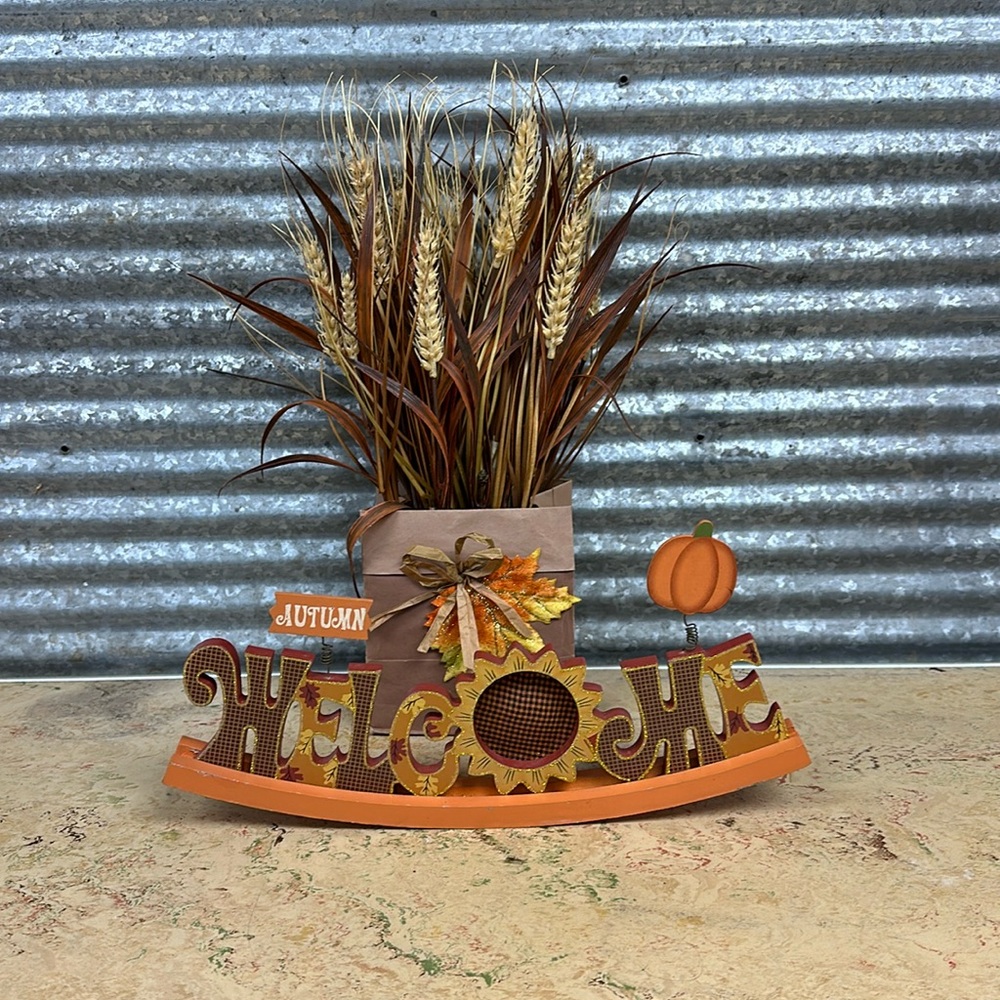 Welcome autumn curved sign and faux grass and in a paper bag